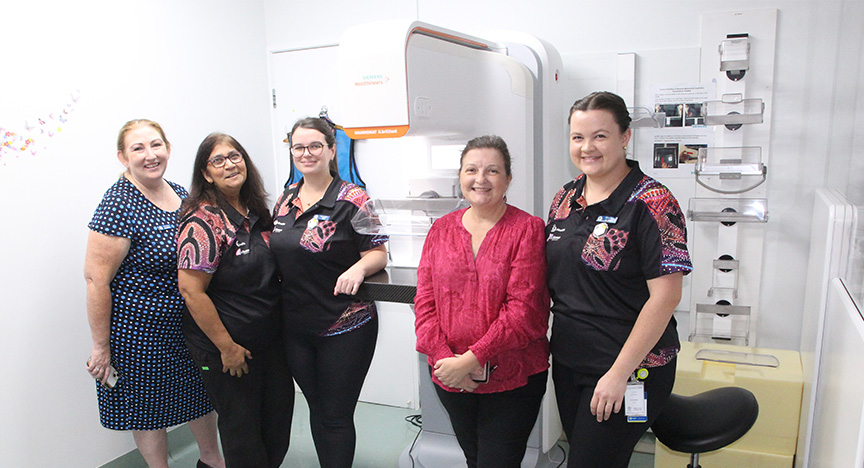 Five CQ Health and BreastScreen Queensland staff stand smiling in a hospital room with the new Siemens Mammomat B.brilliant mammography machine.