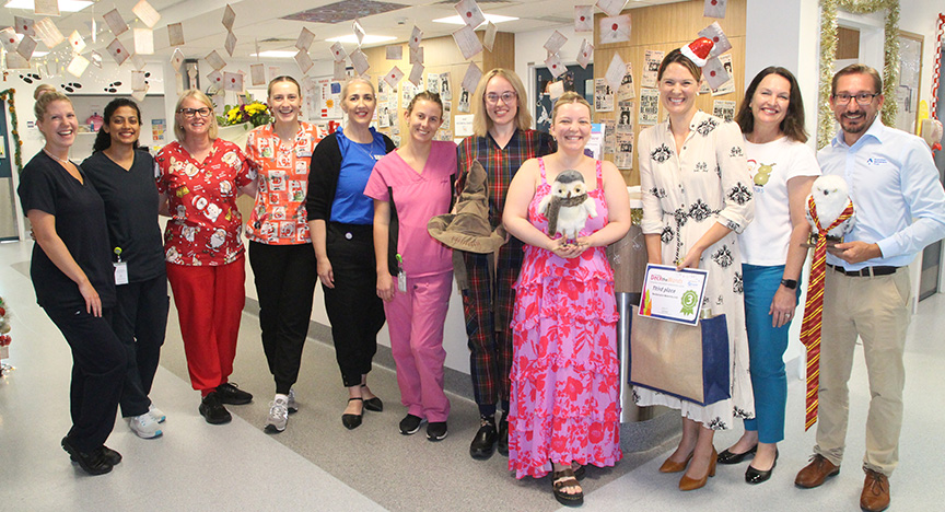 Third place winners at Rockhampton Maternity Unit standing amongst their Harry Potter themed display and receiving their prize.