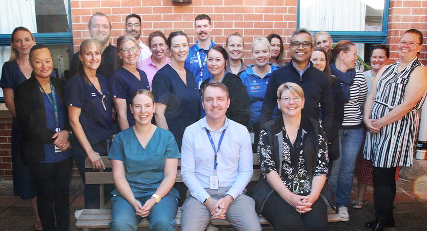 A large group of Public Health Unit staff, including Gulam Khandaker, pose together and smile at the camera.