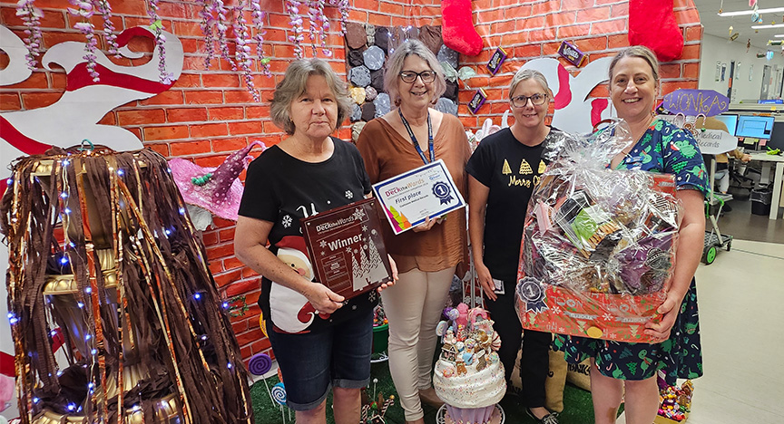 First place winners at Gladstone Hospital Medical Records standing with their Willy Wonka themed display and receiving their prize.