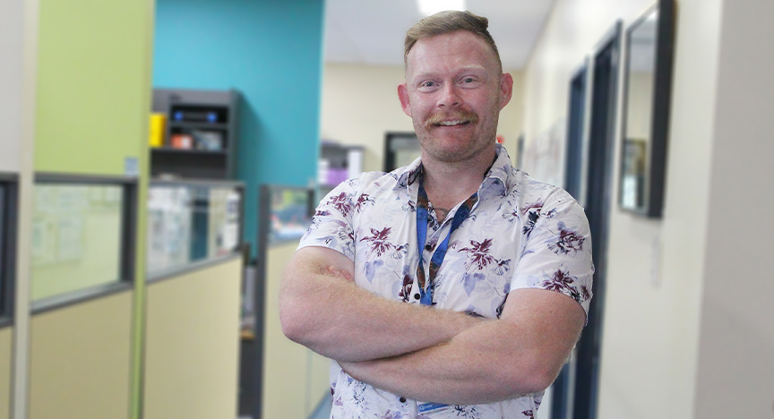 Clinical Nurse Rob standing in corridor and smiling at the camera