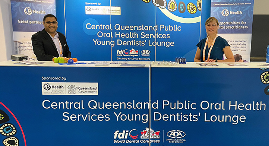 Dr Hitesh Rathi and  Oral Health Therapist Liza Pretorius stand at a booth promoting the Central Queensland Public Oral Health Services Young Dentist's Lounge